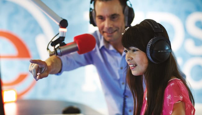 Efteling Kids Radio DJ Arnoud met kind in studio.